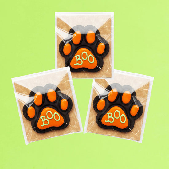 Three Halloween Charcoal Dog Biscuits on Green Background